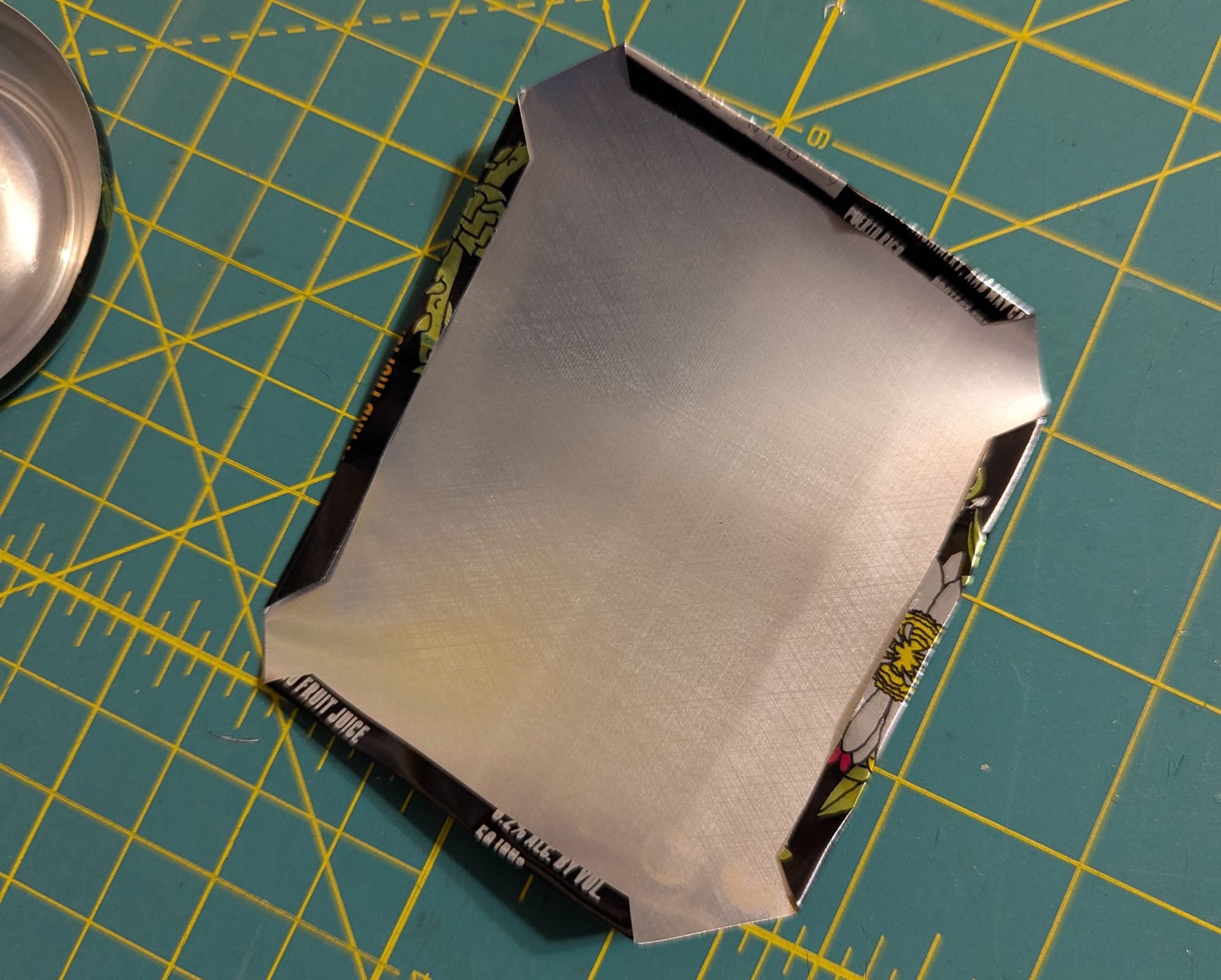 A piece of the aluminum can with each edge folded in towards the center by about an eighth of an inch