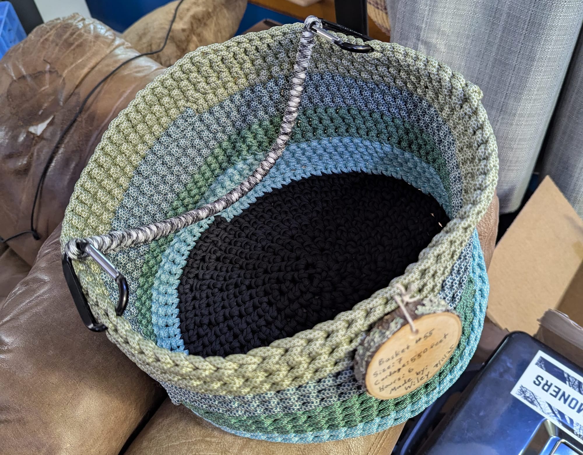 A picture of a crocheted basket made from pastel paracord in shades of blue and green