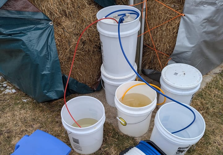 A reverse osmosis system filtering maple sap. It mostly looks like a bunch of white buckets with tubes running between them.