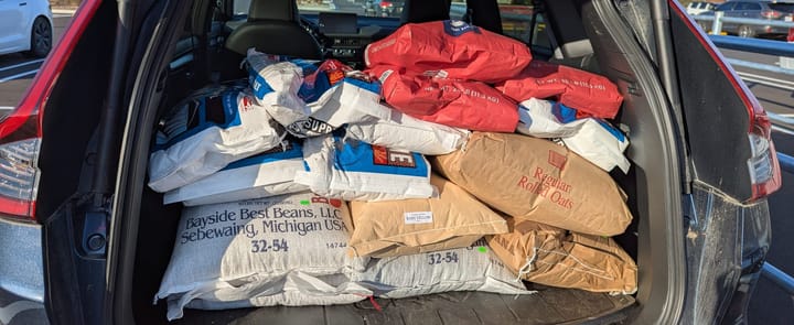 The open trunk of a car, showing lots of bags of bulk food